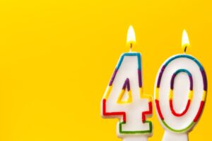 Number 40 in white birthday candles against a yellow background