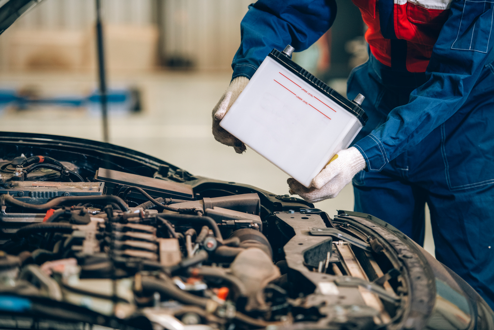 Male mechanic changing car battery, engineer is replacing car battery because car battery is depleted