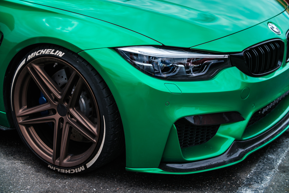 green sports car with low profile tires