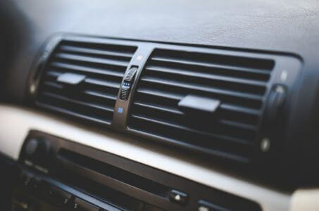 car dashboard air vents delivering airflow from the air conditioning system