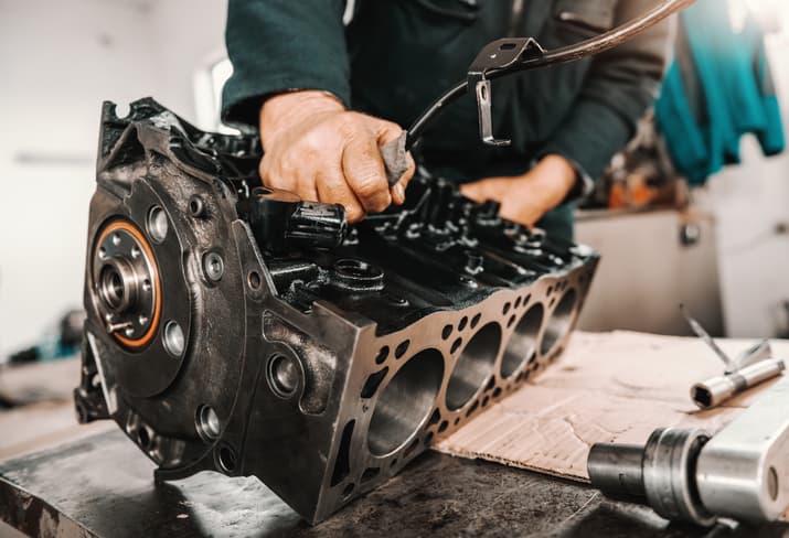 Mechanic working on an engine block during automotive repair
